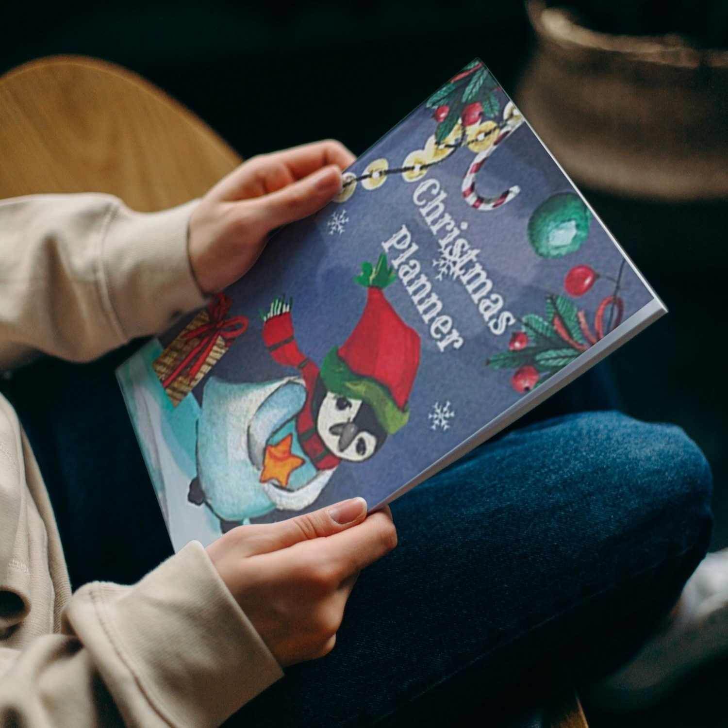 The penguin Christmas planner by Arisateam in the hands of a woman.