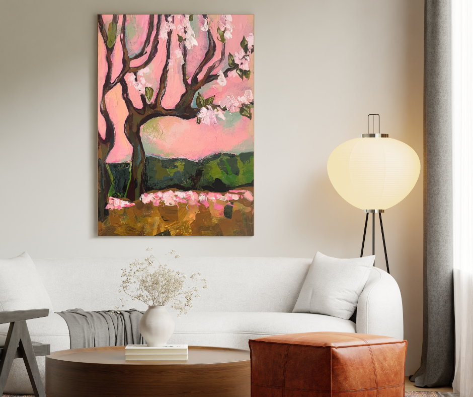 Cherry Blossom Dream canvas wall art displayed above a white sofa in a cozy living room with soft pink floral landscape painting