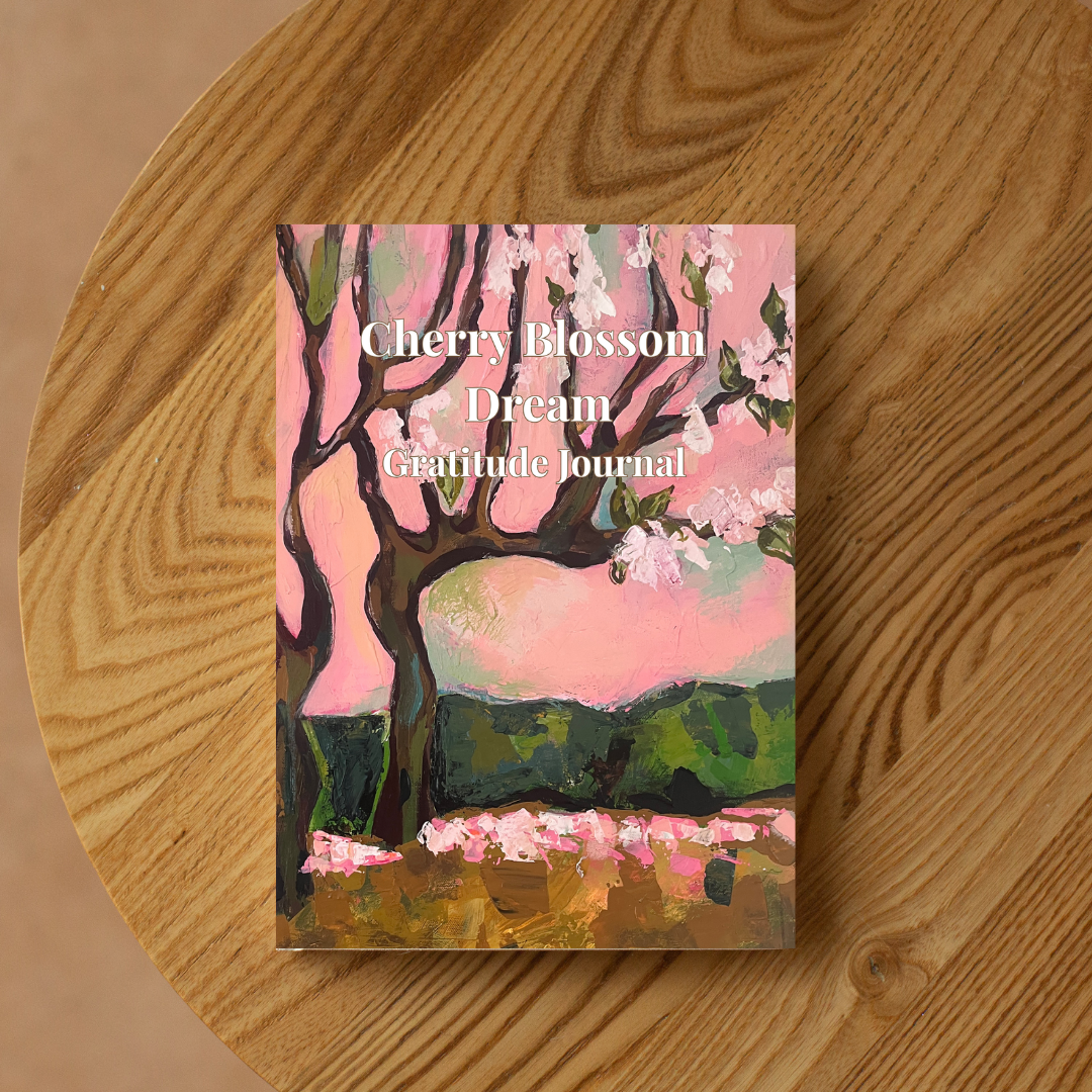 Cherry Blossom Dream gratitude journal with floral artwork placed on a wooden table, aesthetic journal for mindfulness and daily gratitude