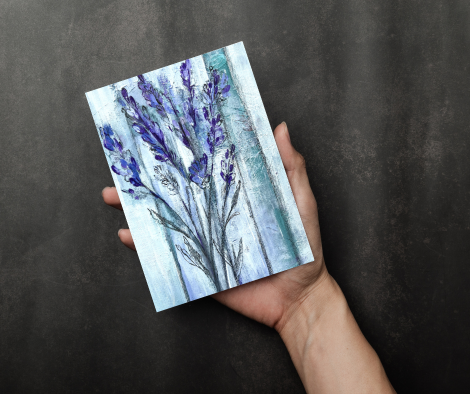 Ethereal lavender greeting card with soft abstract floral artwork held in a hand against a dark background