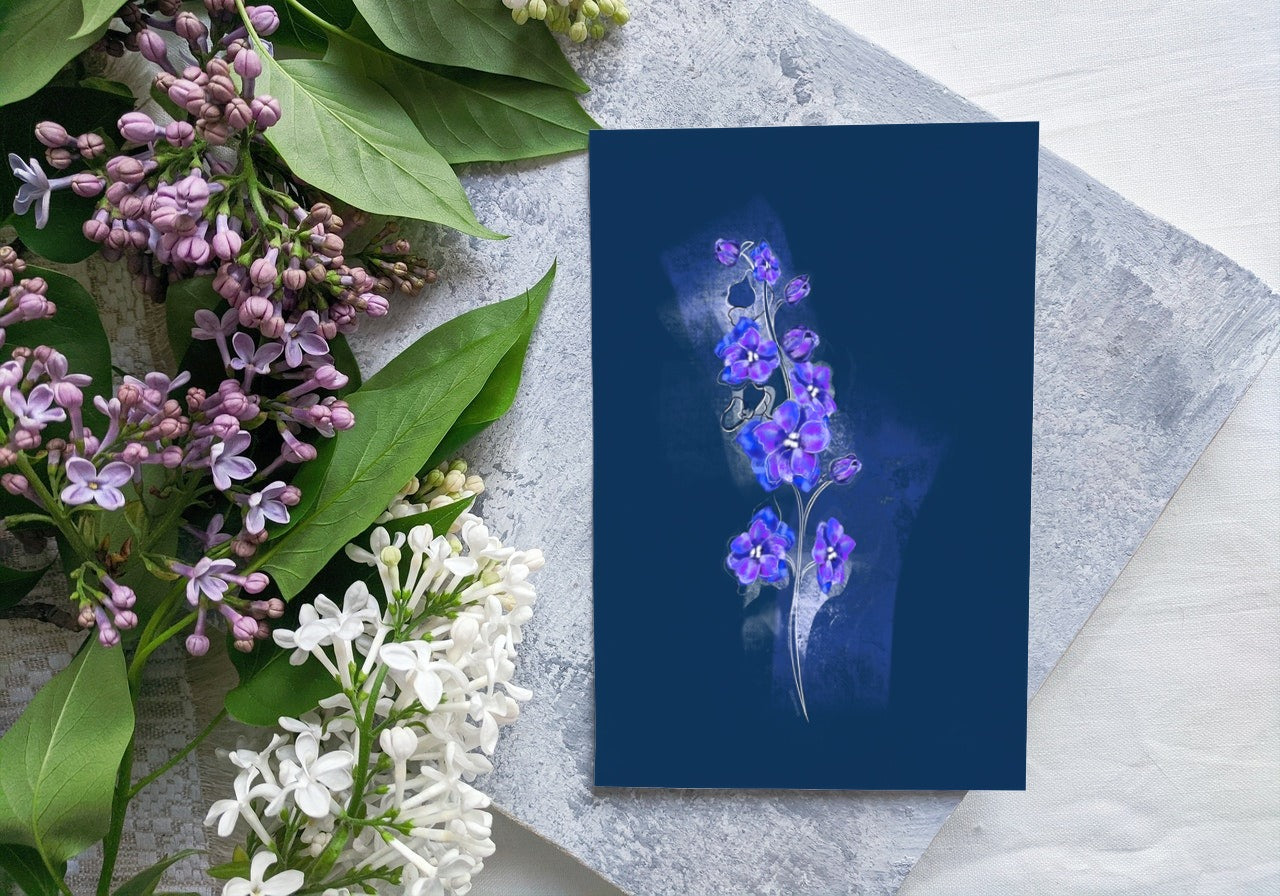 July Larkspur birth flower greeting card displayed beside green flowers