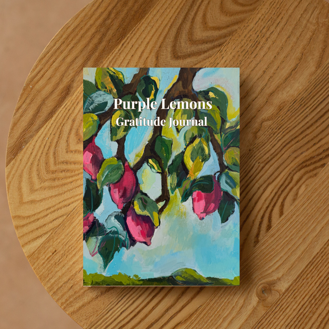 Purple Lemons gratitude journal with colorful lemon tree artwork placed on a wooden surface