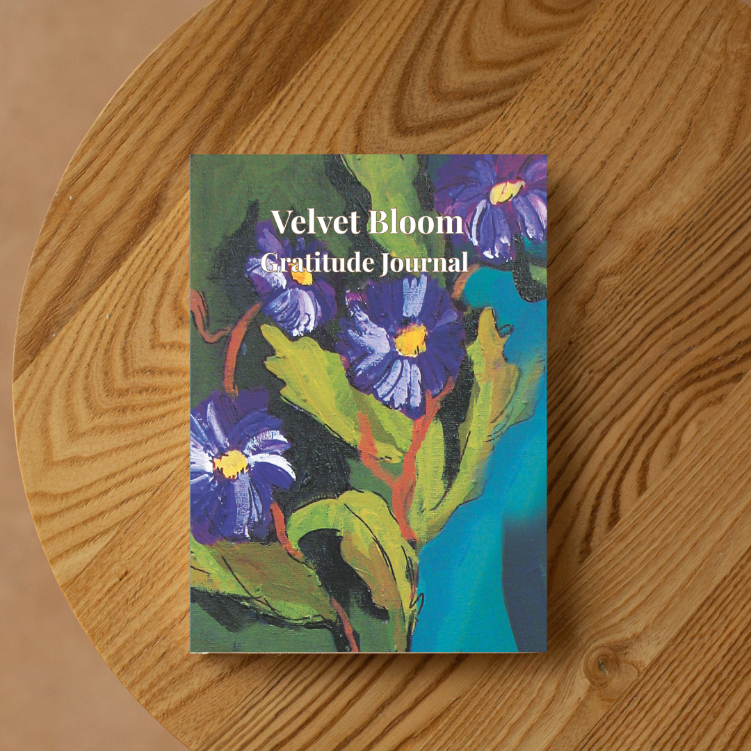 Velvet Bloom gratitude journal with floral artwork placed on wooden table, aesthetic journaling notebook for mindfulness and daily reflection