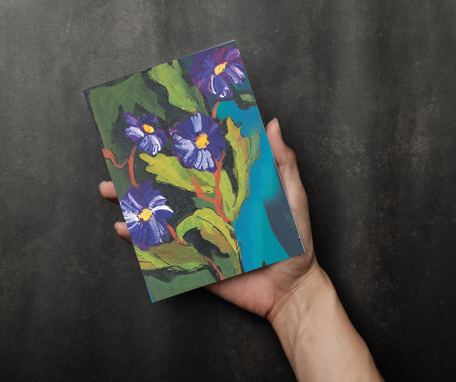 Hand holding Velvet Bloom greeting card featuring abstract impressionist floral artwork against a dark background