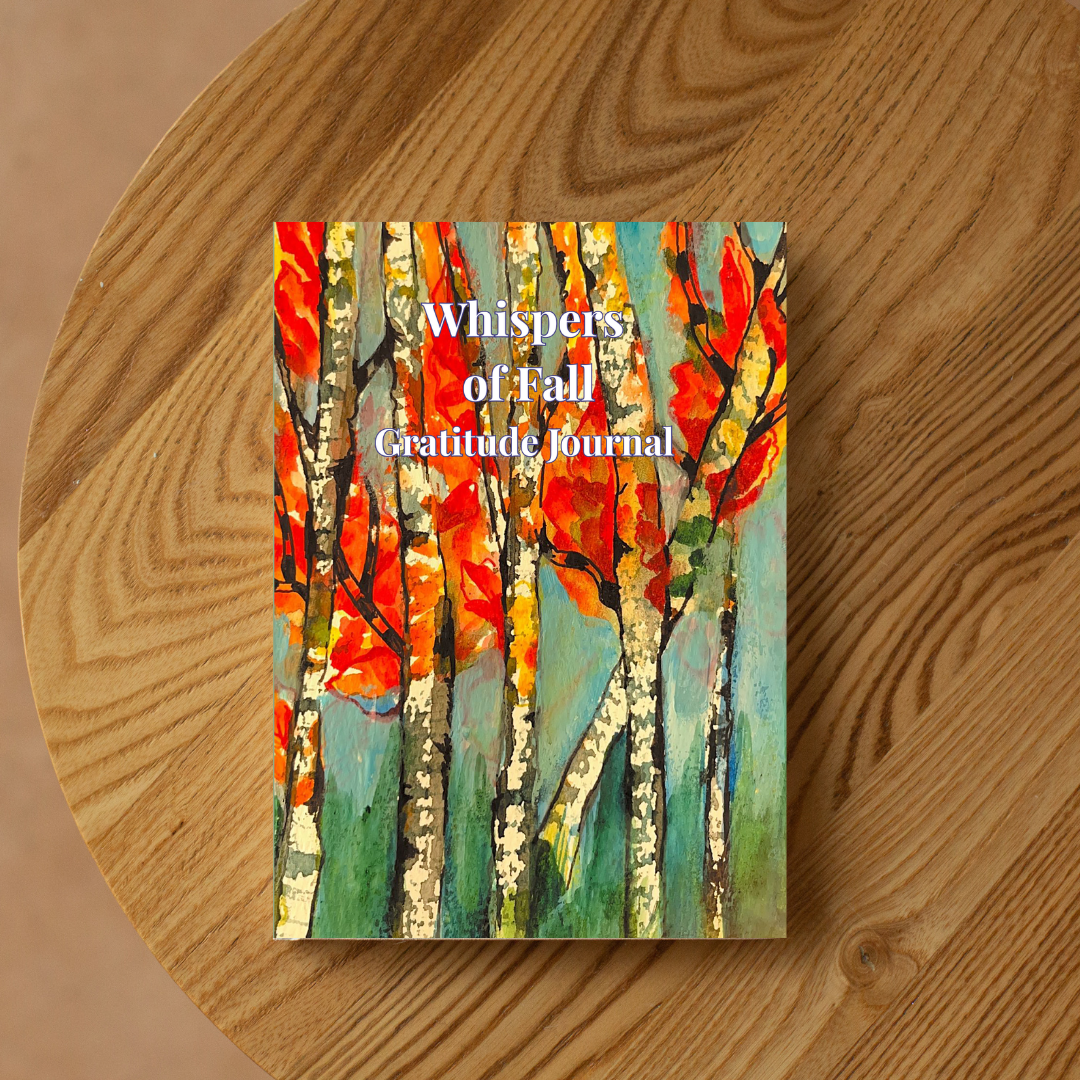 Whispers of Fall gratitude journal with autumn artwork placed on a wooden table in a warm, natural setting