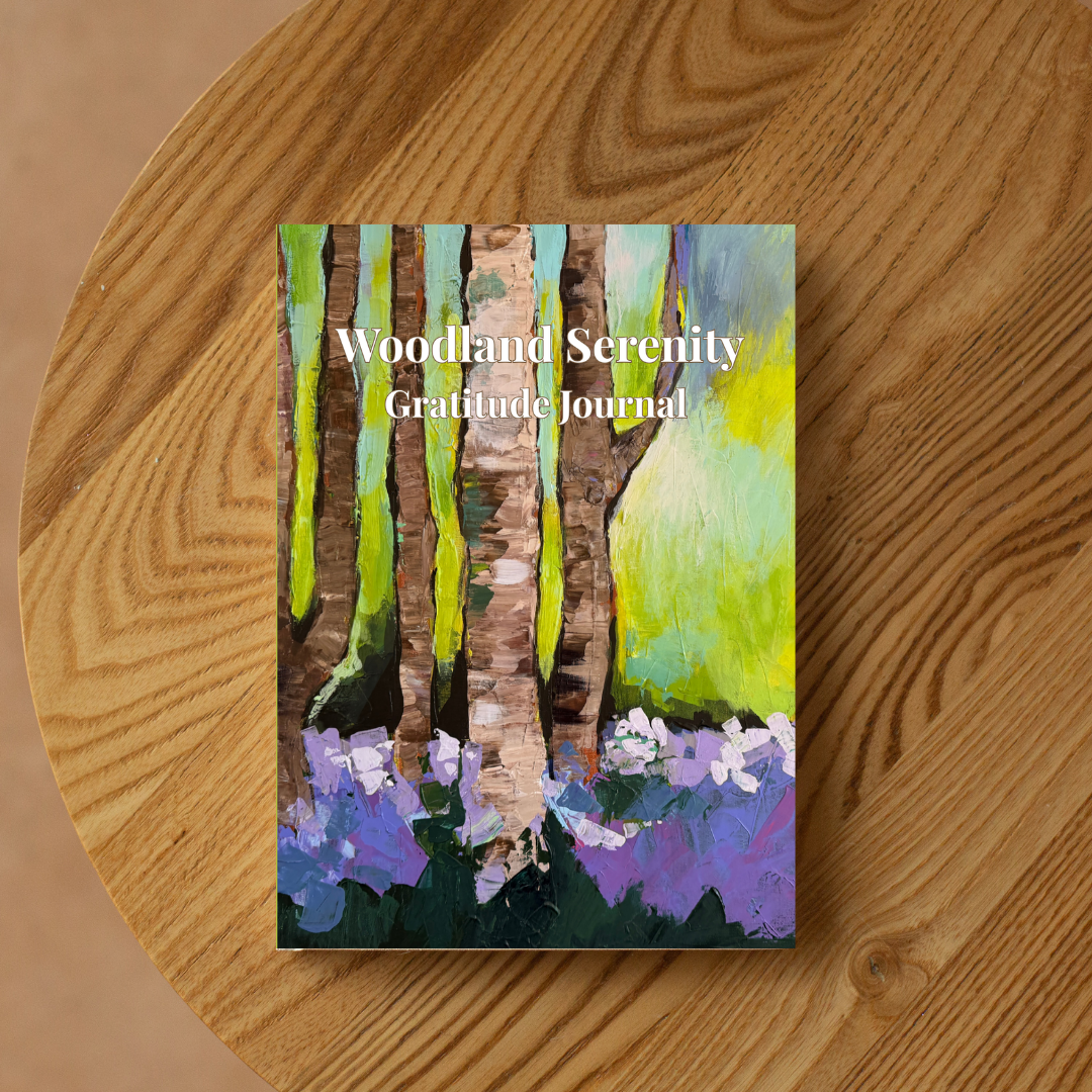 Woodland Serenity gratitude journal with forest-inspired artwork placed on a wooden table in a warm, natural setting