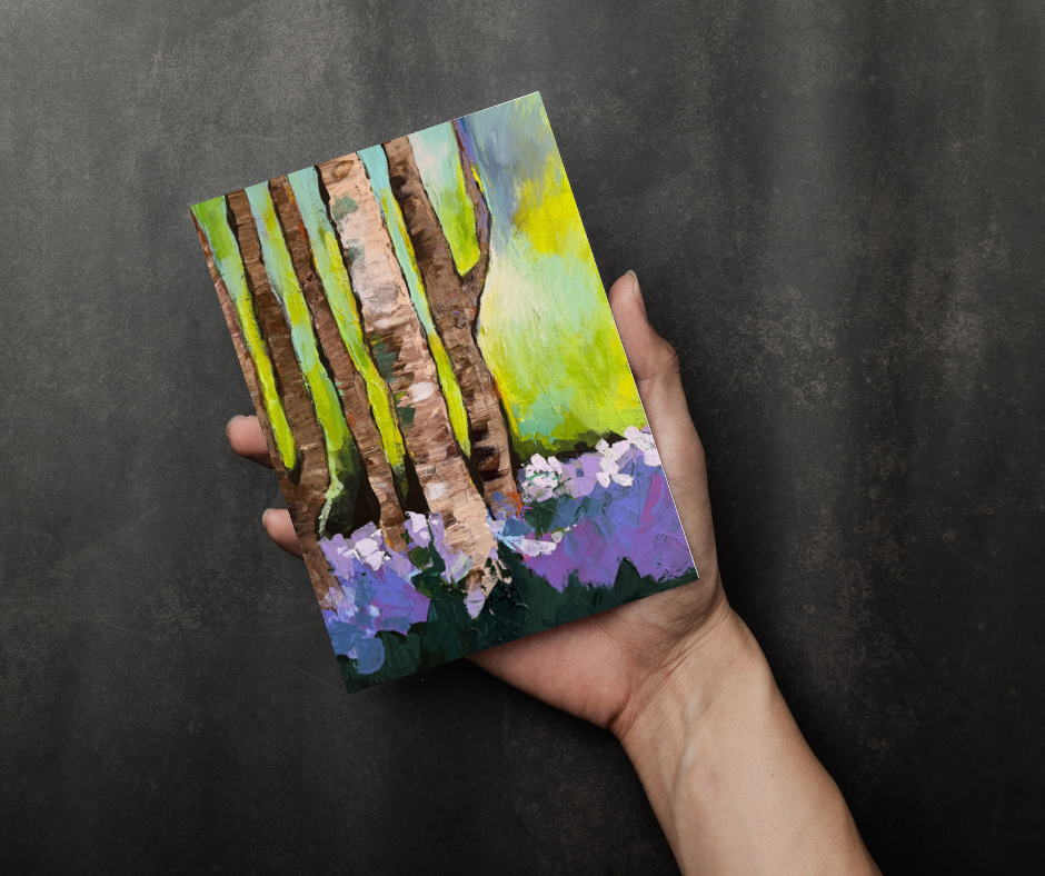 Woodland Serenity greeting card with impressionist forest artwork held in hand against a dark background