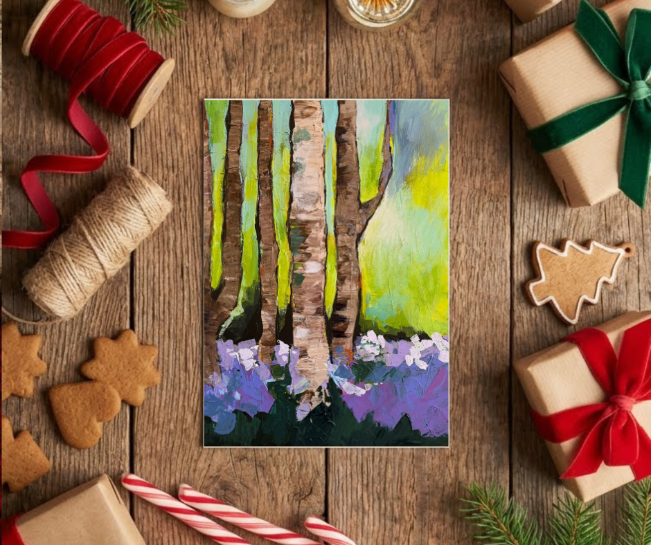 Woodland Serenity greeting card with impressionist forest artwork displayed on a wooden table with holiday decorations and gift wrapping