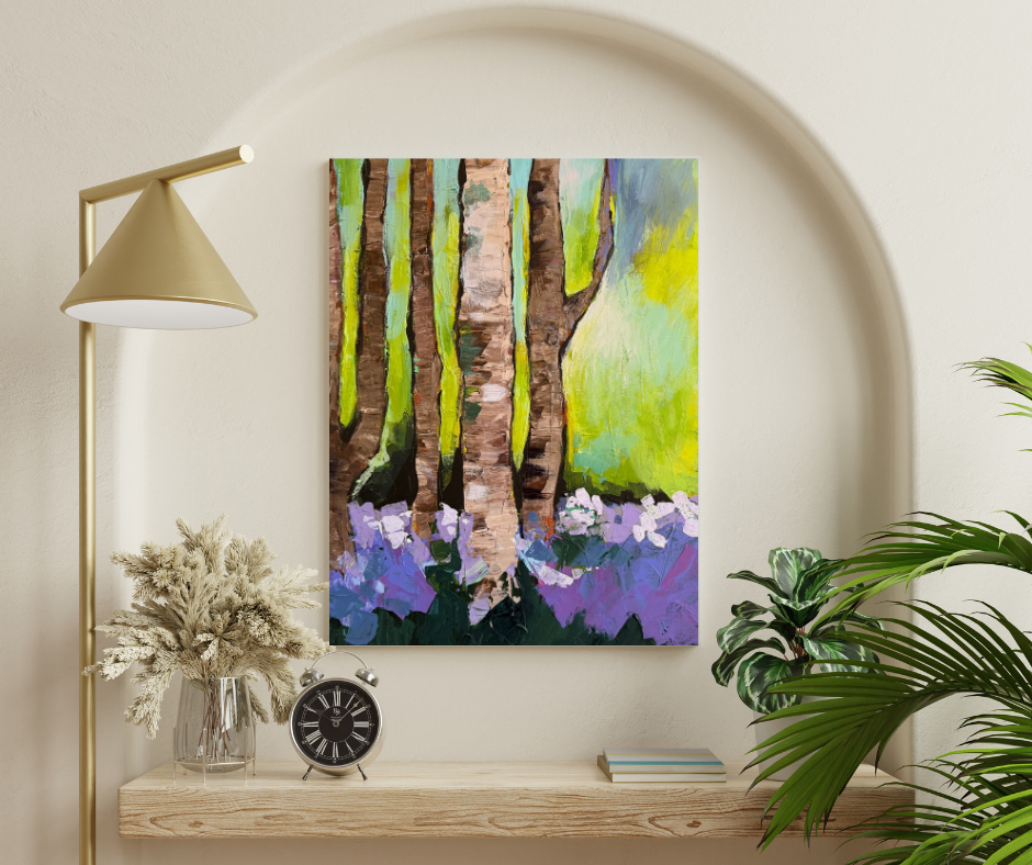Forest canvas wall art in green and purple tones displayed above a wooden shelf with lamp and plants in a calm modern space