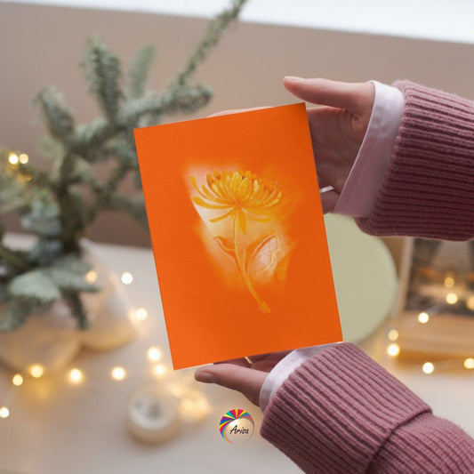 "Chrysanthemum" Greeting Card by ArisaTeam in the hands of a woman and in a Christmas background ideal as a Christmas card.